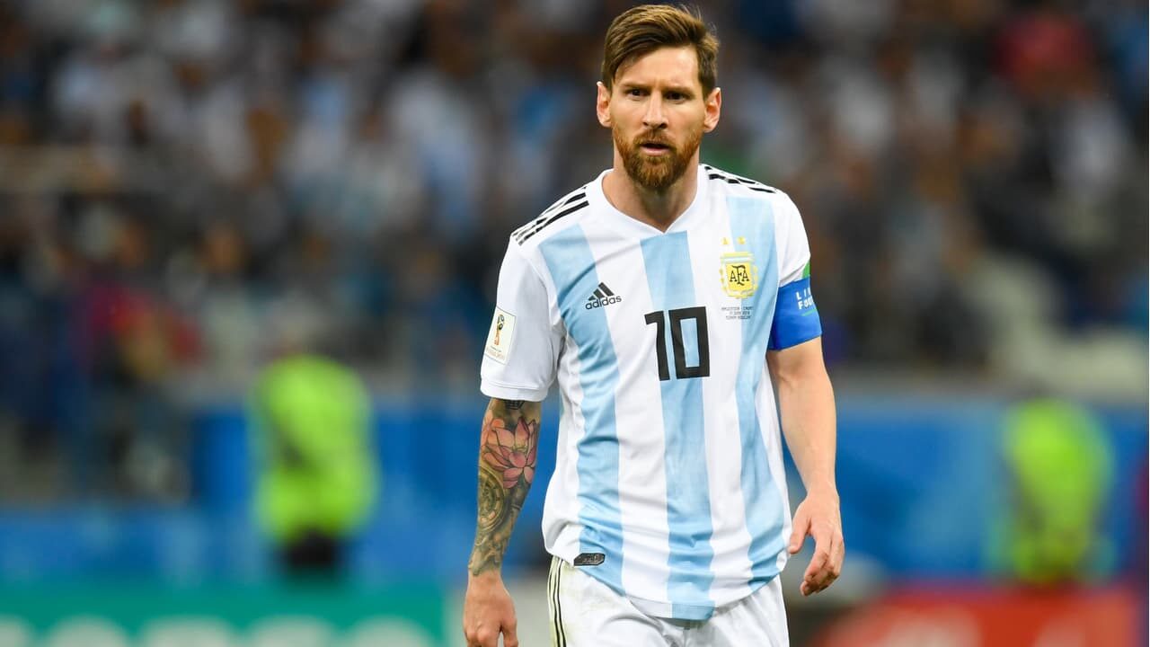 Jogador Messi com uniforme da seleção da Argentina em campo