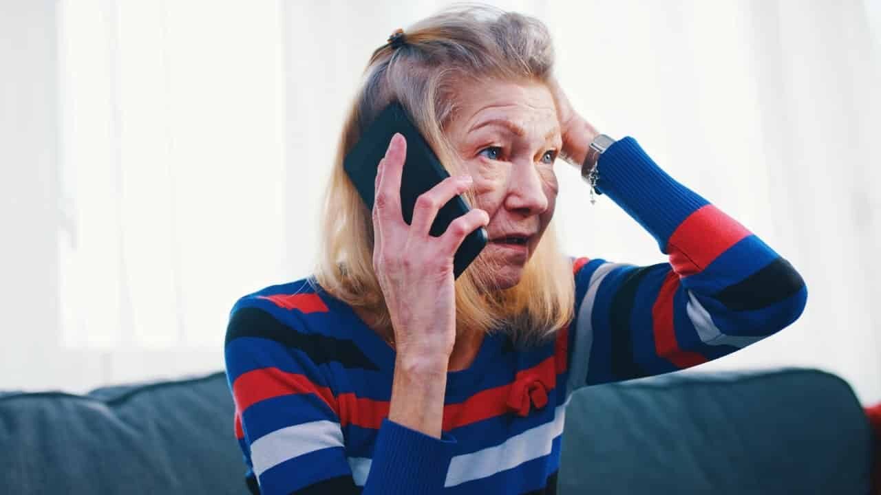 Mulher falando ao telefone com expressão de preocupação