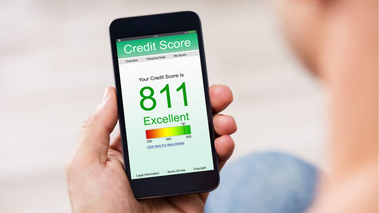 Pessoa segurando celular que mostra score de crédito excelente