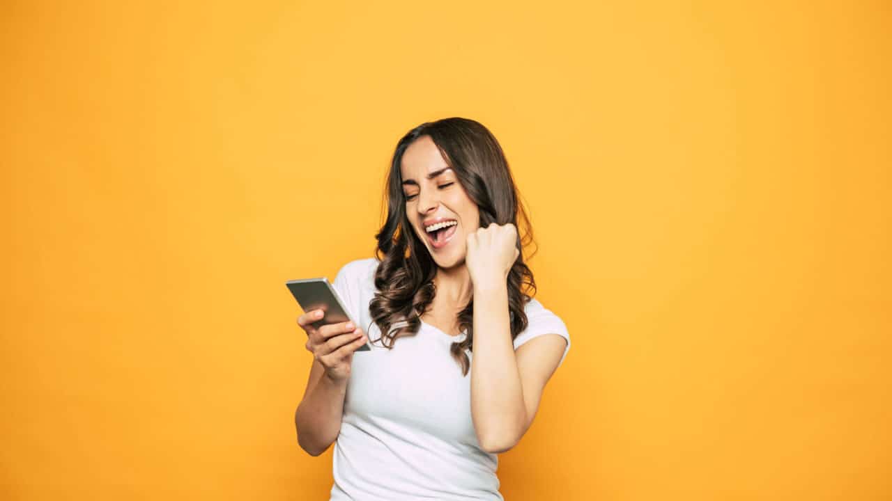 Mulher olhando para o celular feliz