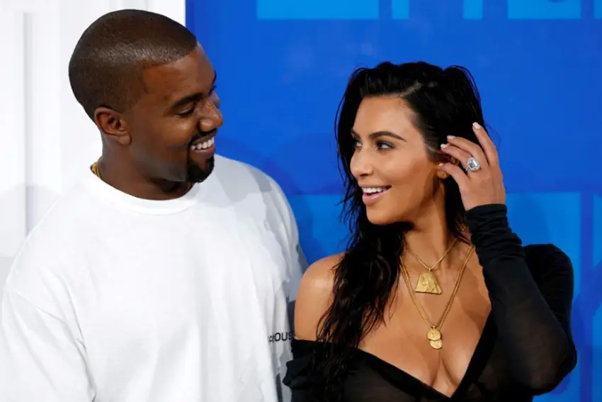 A esquerda Kanye West e a direita Kim Kardashian quando ainda eram um casal. Ambos posam para foto se olhando e sorrindo