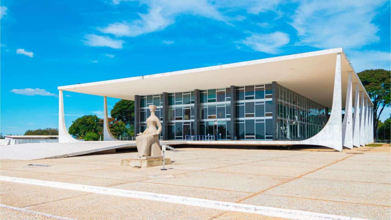 Foto ampla do prédio do STF com a estátua à frente