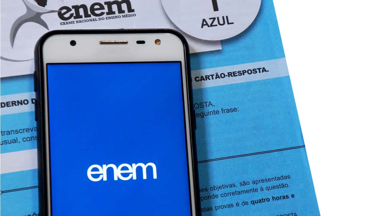 Tela de celular com logo do Enem sobre exemplar de prova do exame