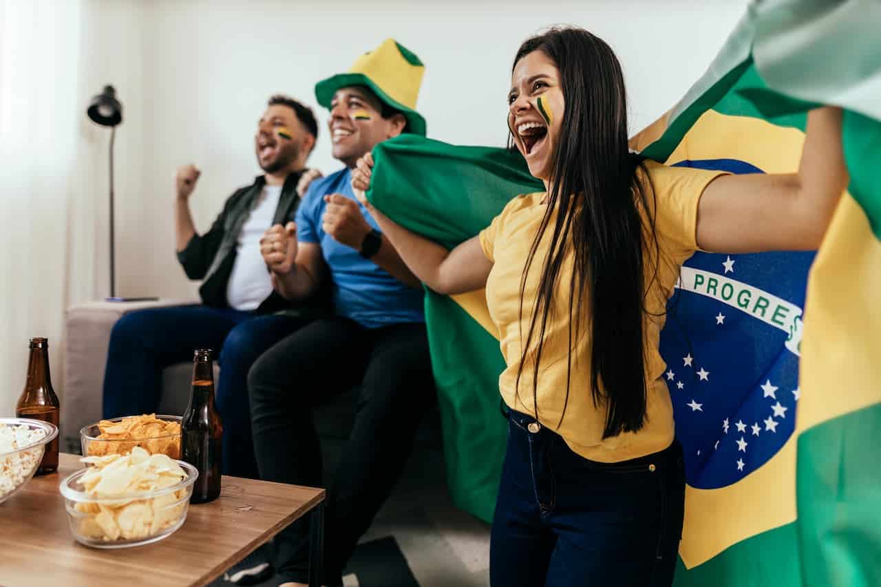 Torcedores do Brasil vestidos de verde e amarelo com bandeira nacional