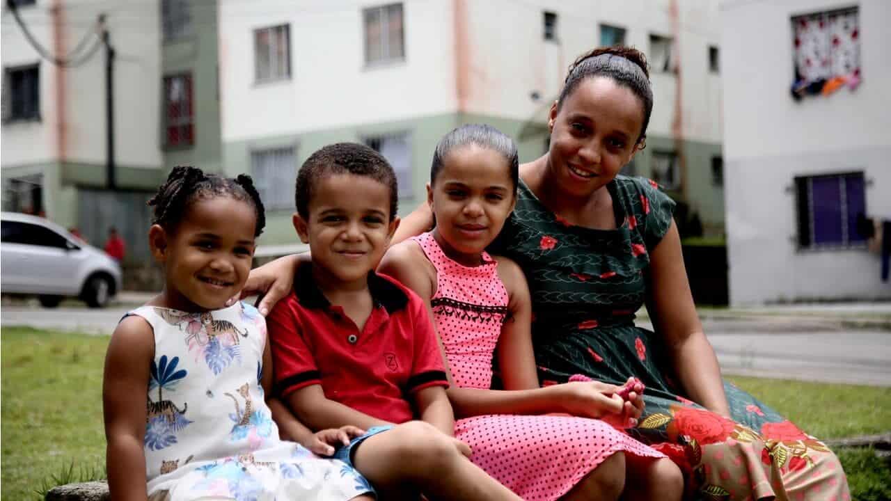 Uma mulher com três crianças sorrindo