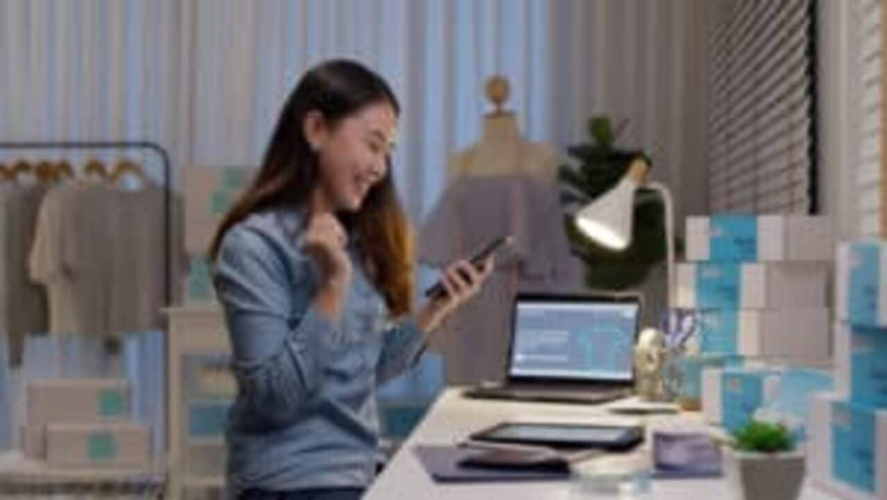 mulher segurando o celular e sorrindo