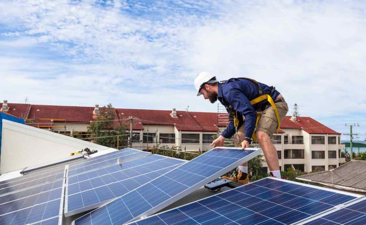 homem instalando placas solares para o uso da energia do sol
