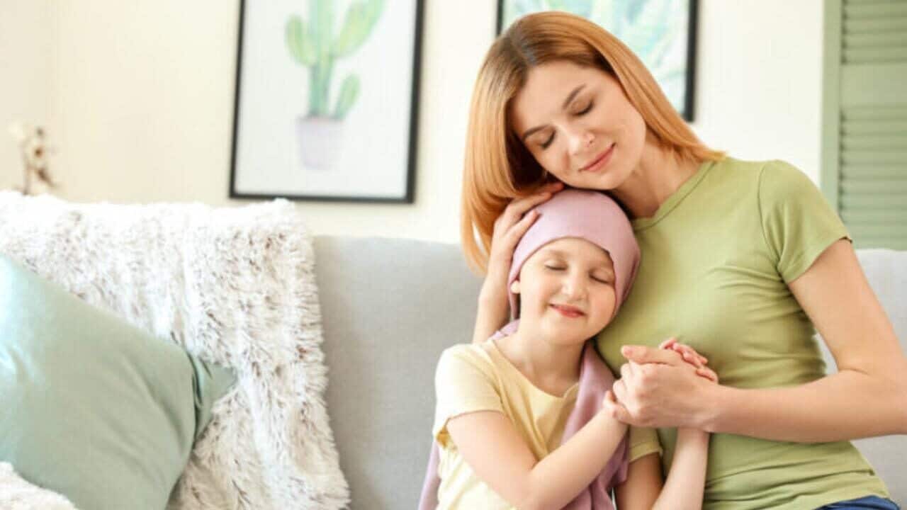 imagem de mãe e criança com câncer se abraçando