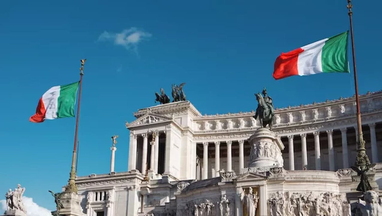 Monumento em homenagem a Vítor Emanuel II da Itália com bandeiras da Itália ao lado.