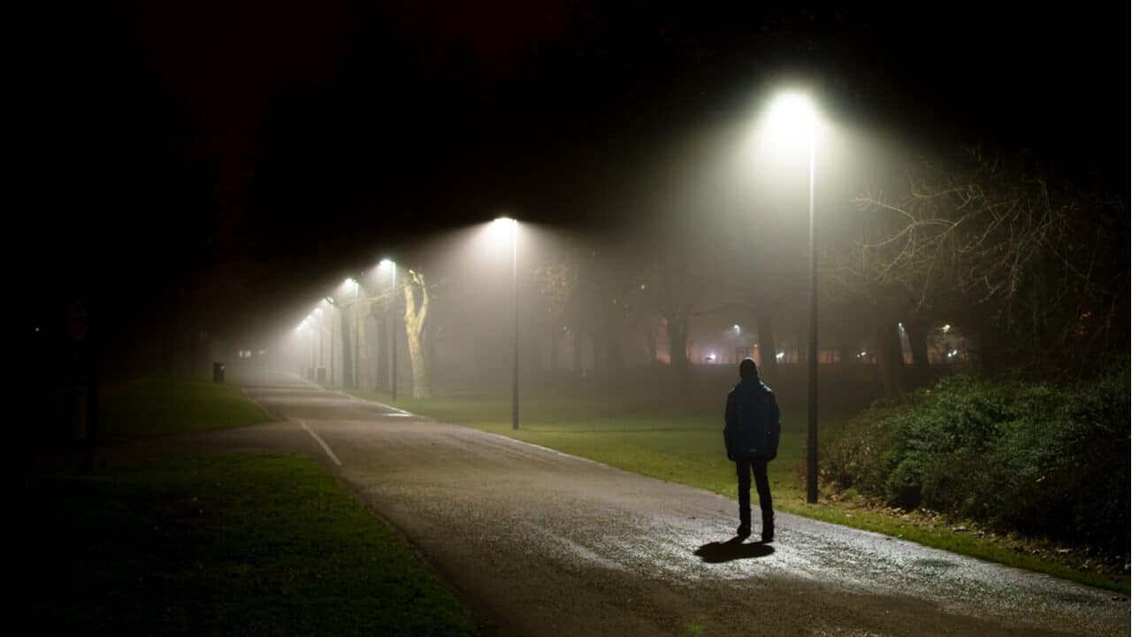 Pessoa andando sozinha à noite
