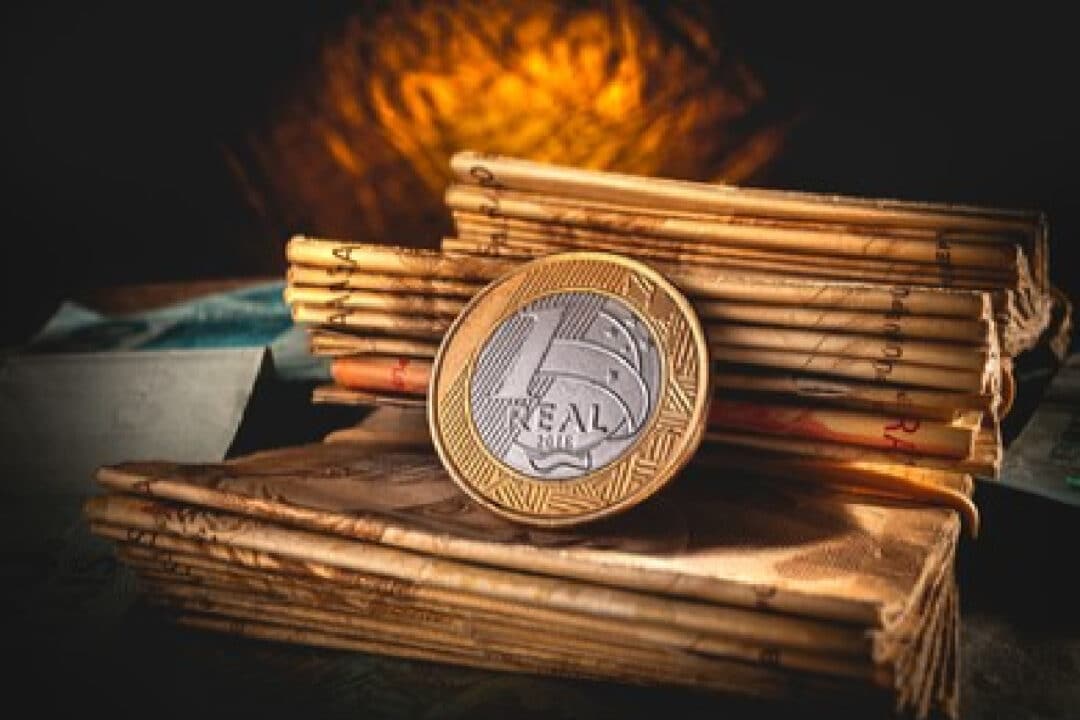 Moeda de R$1 depositada em notas de R$50 empilhadas - tesouro direto
