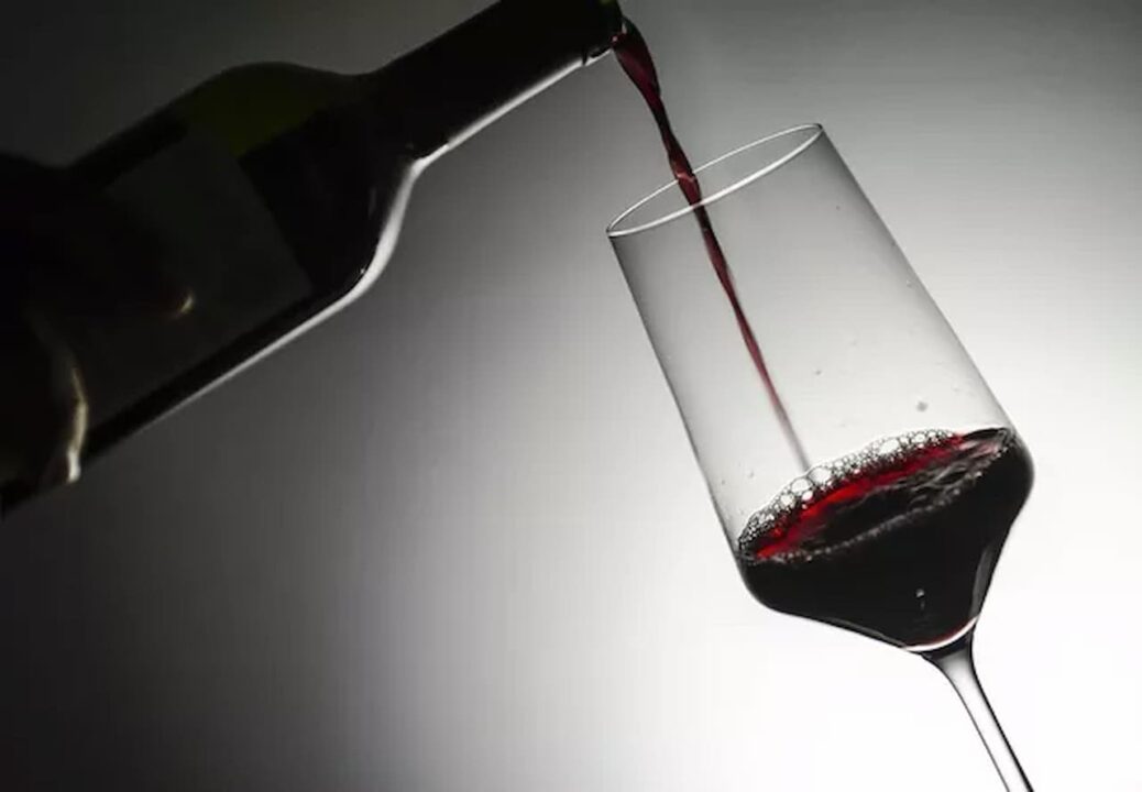 Garrafa de vinho servindo taça