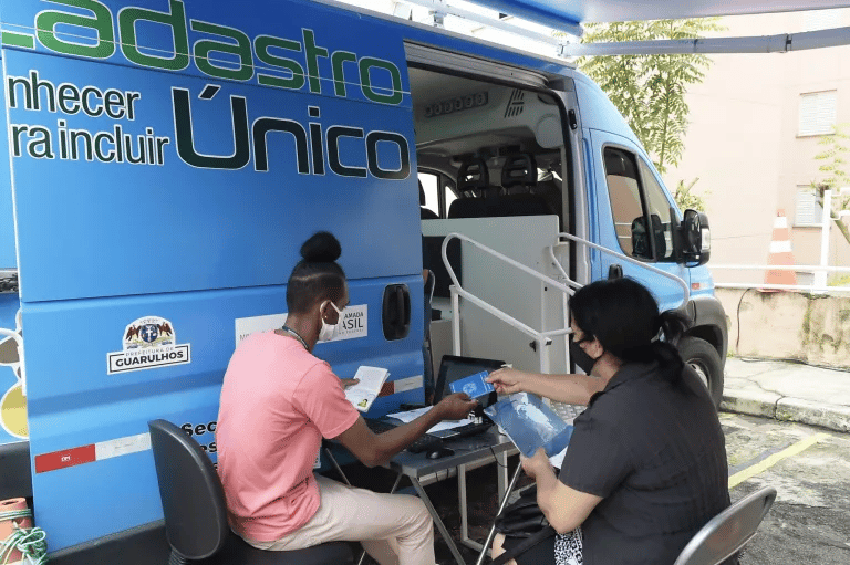 Van do CadÚnico e uma pessoa sendo atendida pelo agente