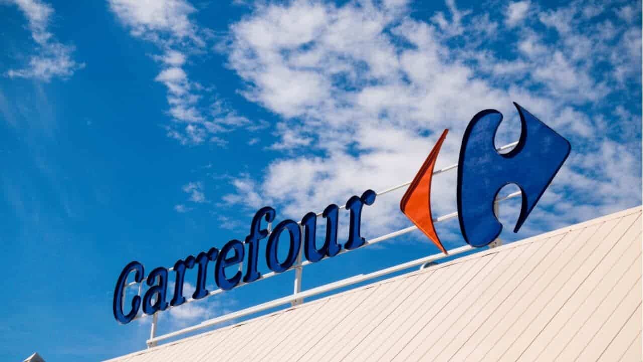 Fachada do supermercado Carrefour, com letreiro na parte superior e céu ao fundo