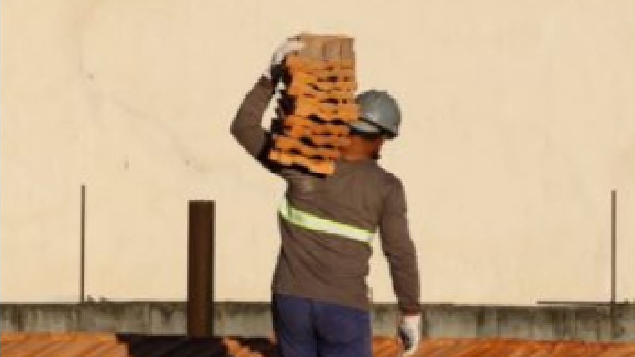 Pedreiro carregando materiais de construção no ombro