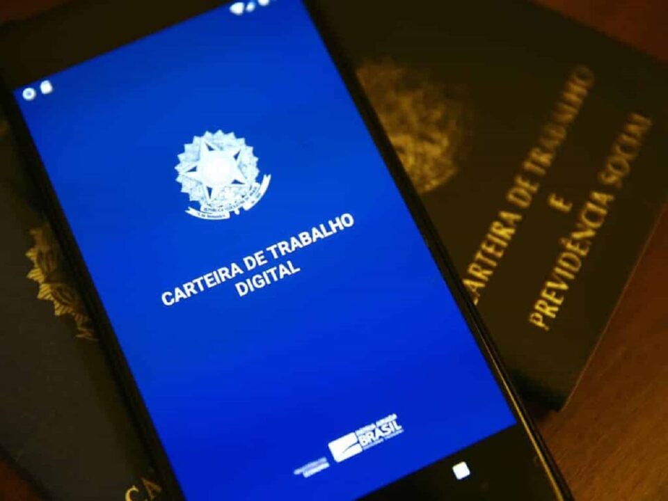 imagem de carteira de trabalho digital no celular e carteira de trabalho física ao fundo