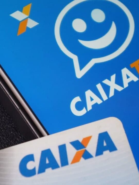 Cartão da Caixa sobre um celular que mostra logo do aplicativo Caixa Tem