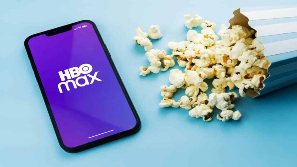 pipocas derrubadas ao lado de um celular que exibe a logo da HBO Max
