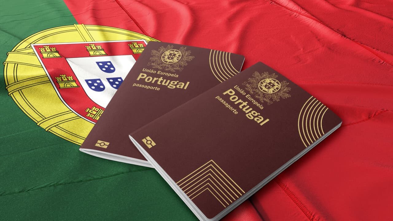 Passaporte português em cima da bandeira nacional de Portugal