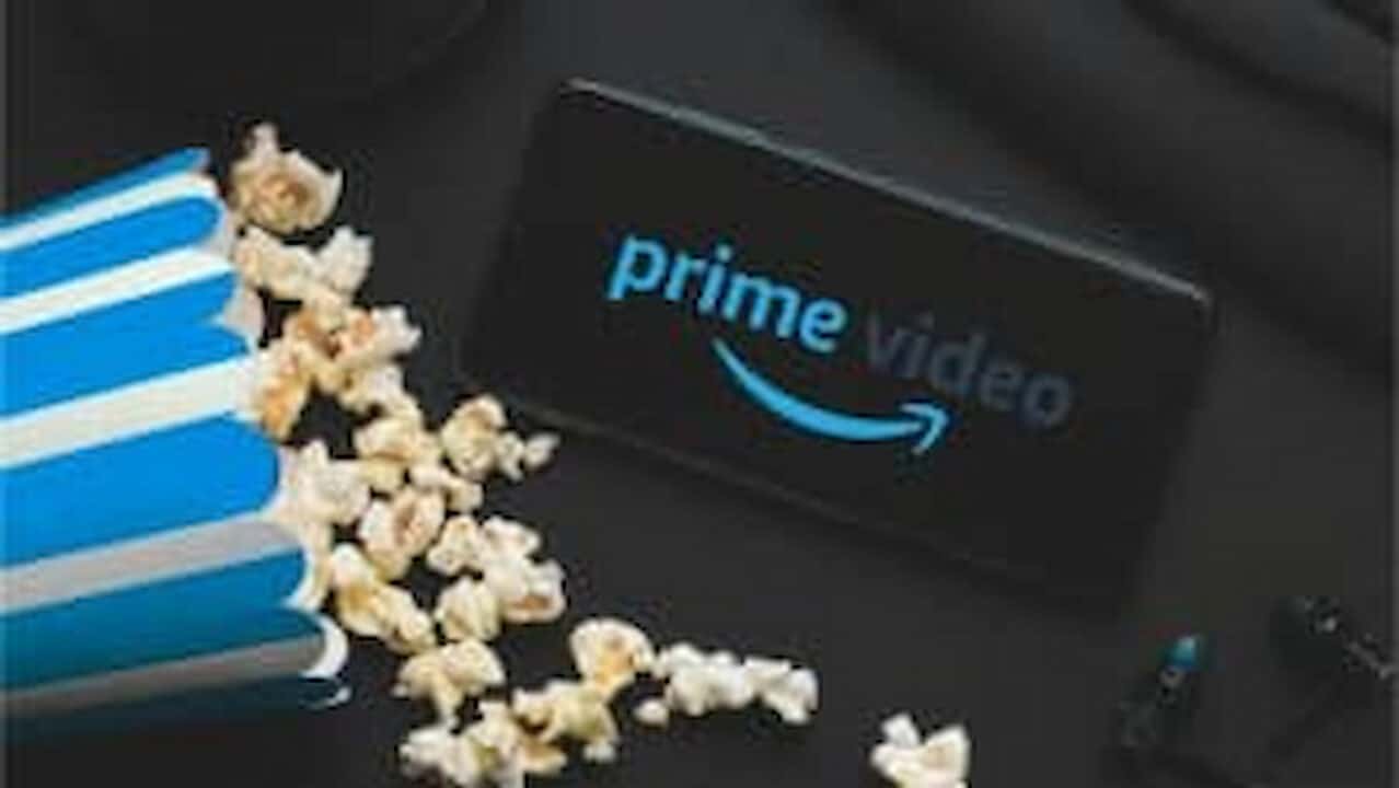 balde de pipoca caído e celular com Prime Video na tela