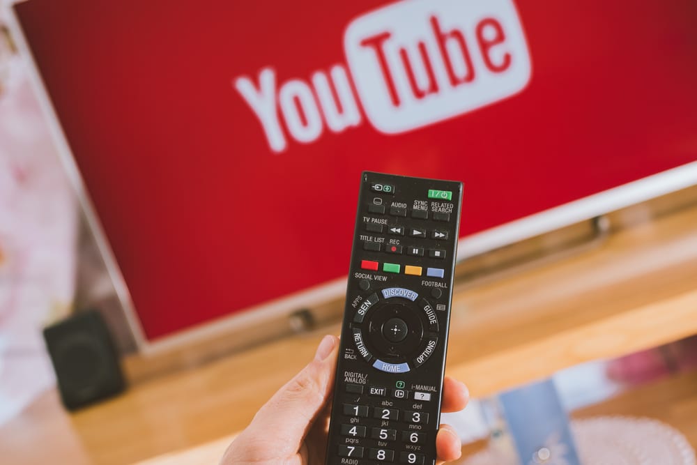 pessoa assistindo tv aberta e gratuita no youtube em casa