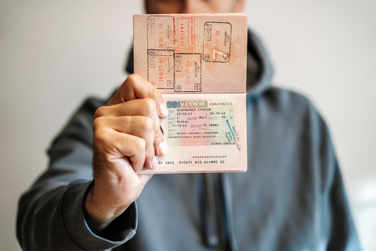 Homem segurando passaporte com visto