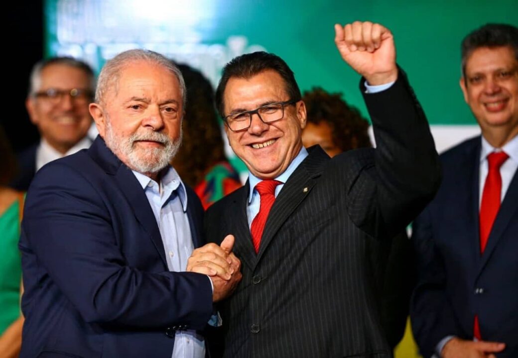 Luiz Marinho, ministro do Trabalho aperta mão do presidente Lula enquanto sorri