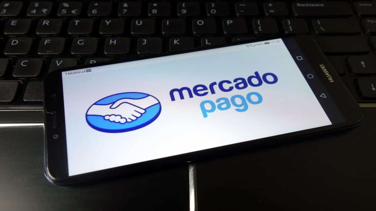 Posicionado em cima de um teclado, celular exibe logotipo do Mercado Pago