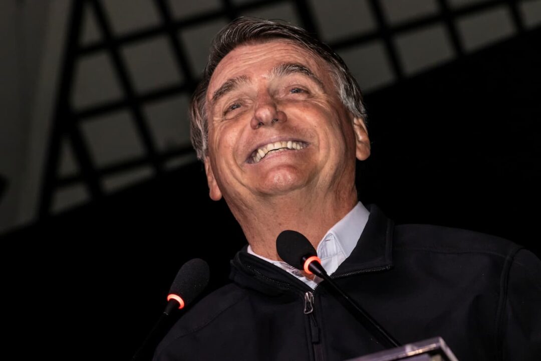 Imagem do ex-chefe de Estado Jair Bolsonaro sorrindo.