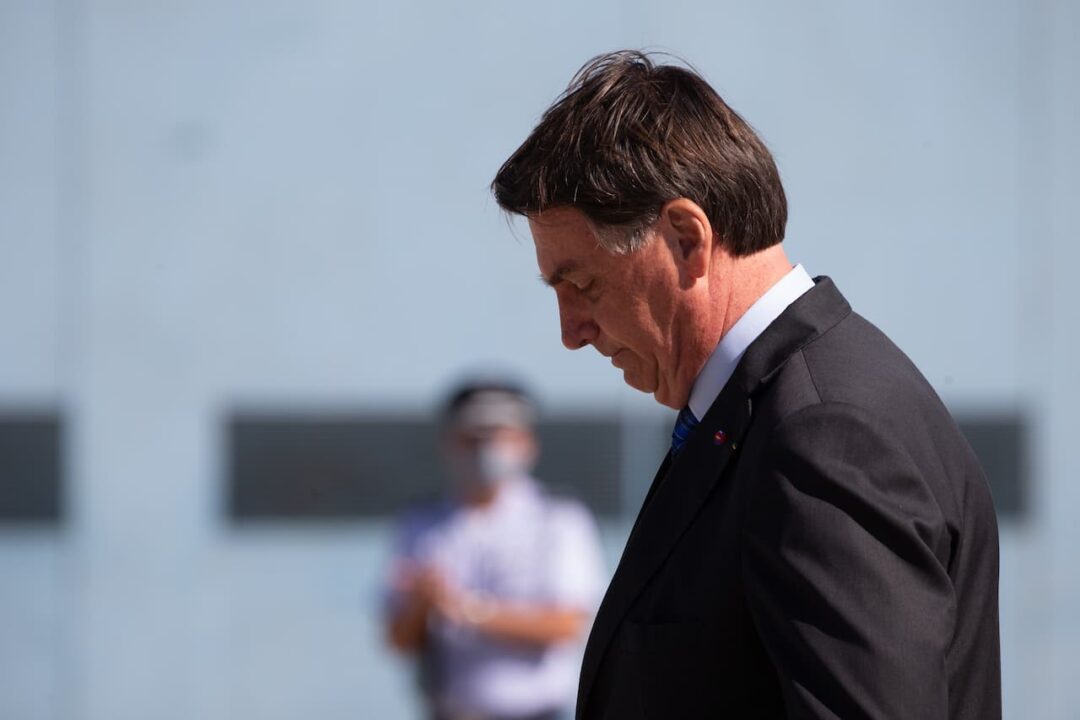Bolsonaro de perfil, aparentemente caminhando, com a cabeça baixa.