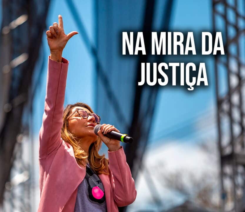 Janja fala ao microfone e faz o símbolo do L com as mãos