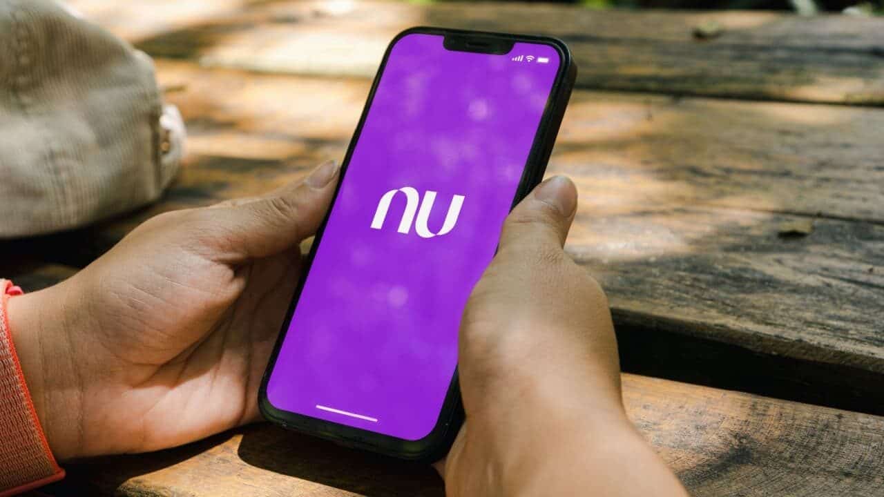 Pessoa mexendo em celular com o aplicativo Nubank aberto.