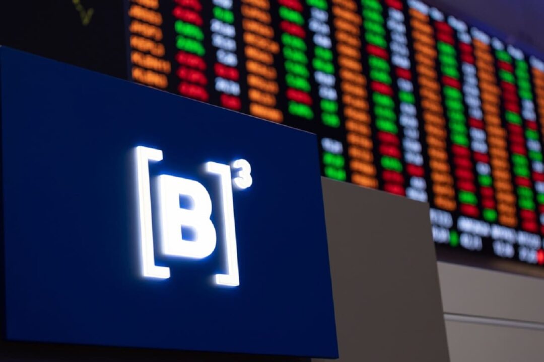 Imagem de gráficos da bolsa de valores brasileira, com o logo da B3 na frente.
