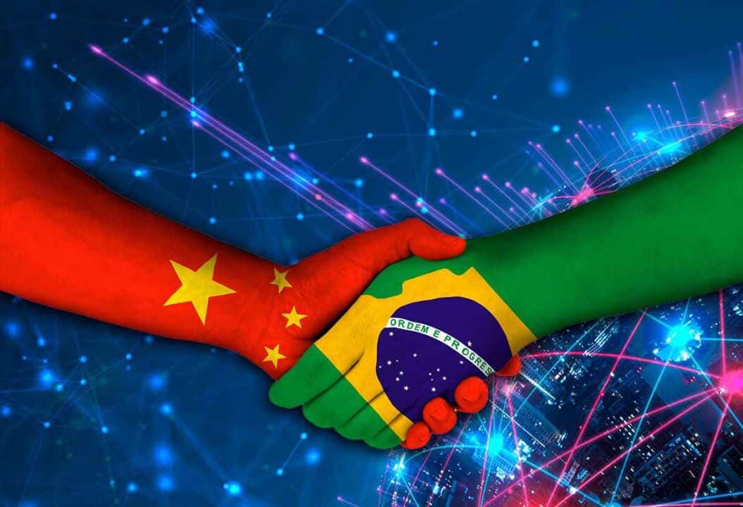 Duas mãos se cumprimentando, enquanto cada uma ilustra as bandeiras do Brasil e da China