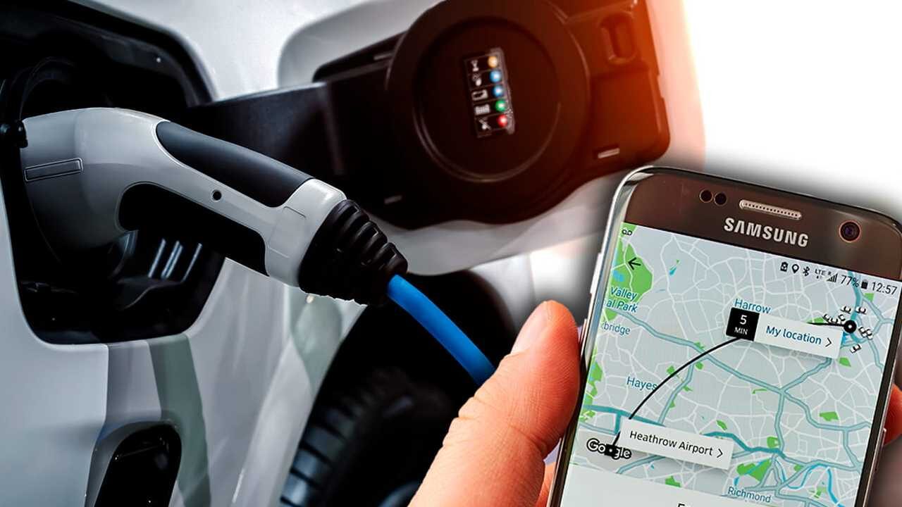 Celular na mão com app de corrida aberto e, ao fundo, um carro elétrico sendo carregado