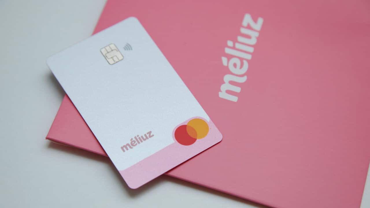 Cartão da conta digital Méliuz sobre um material gráfico com o logo da empresa.