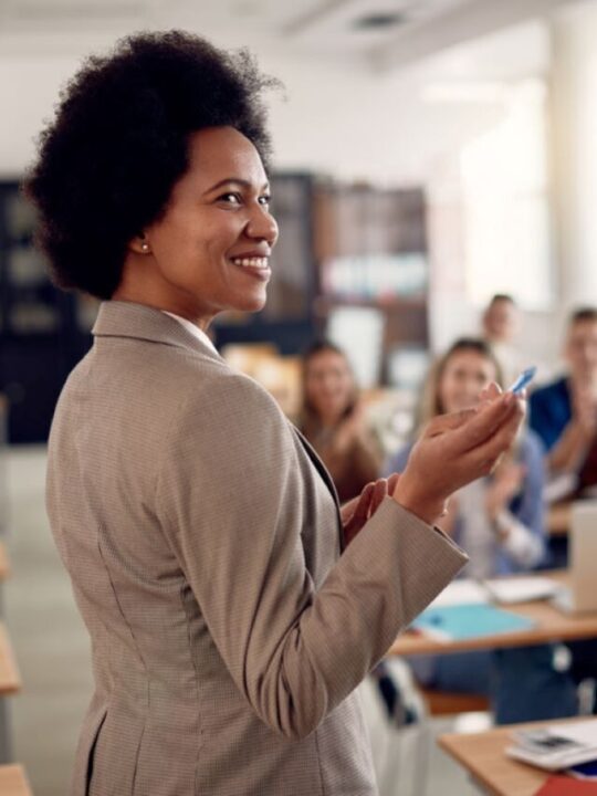 professora em sala de aula sendo aplaudida pelos alunos