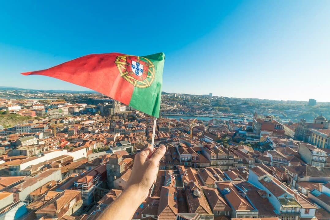 Mão segurando bandeira de Portugal