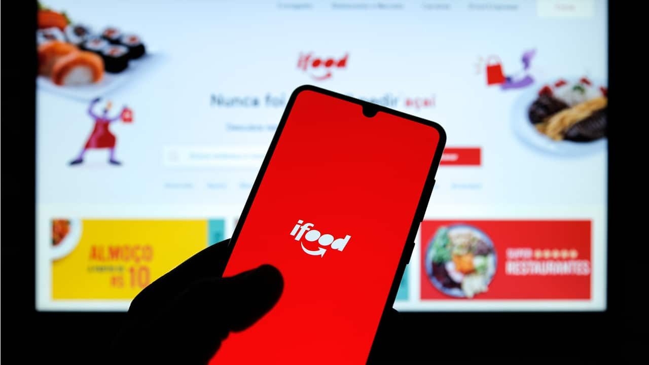 Mão segurando celular com app iFood
