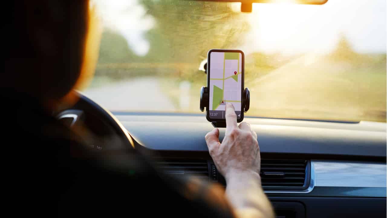 Motorista de app de transporte com o dedo no aplicativo do celular