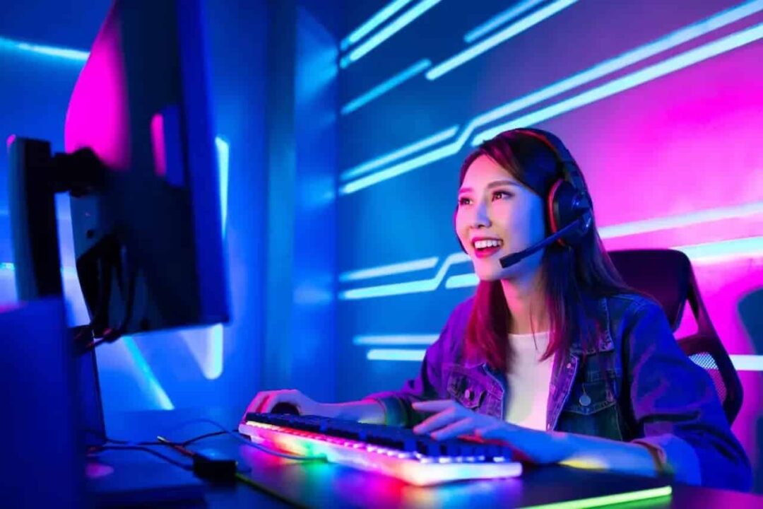 Mulher gamer com fone olhando para monitor de computador