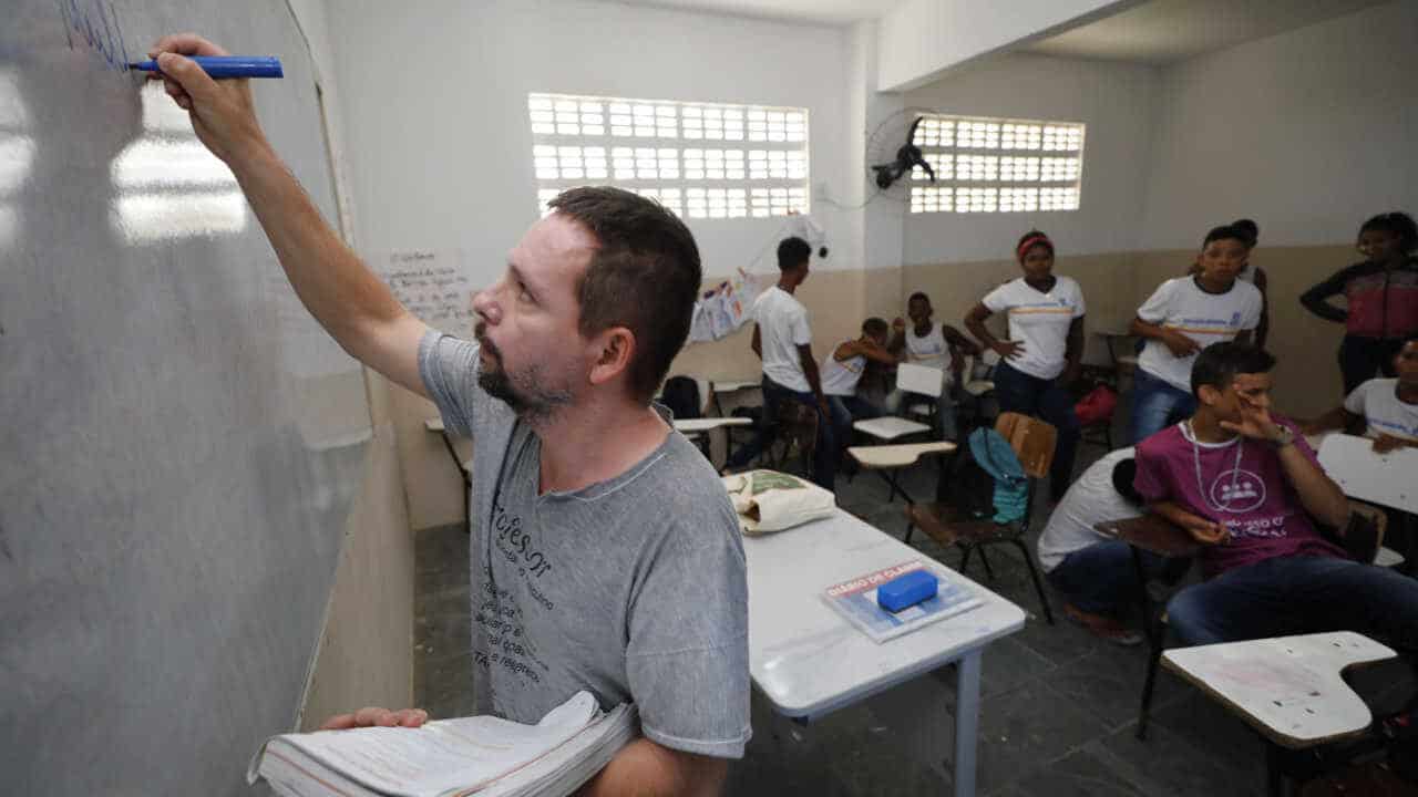 professor dando aula para uma turma do ensino médio de uma escola pública