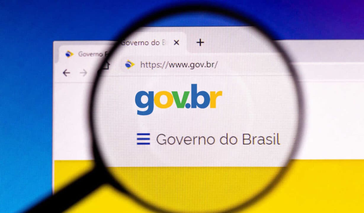 Lupa aumentando uma parte de um monitor que exibe o portal do governo federal, que pode ser acessado com conta bancária