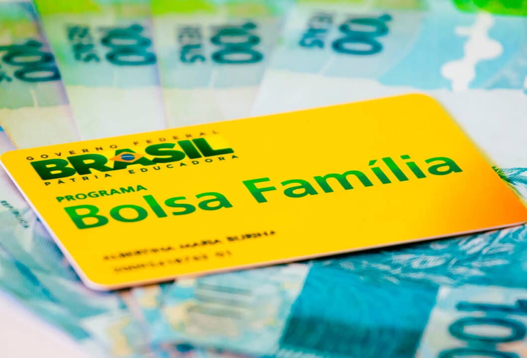 Cartão Bolsa Família em cima de notas de R$ 100