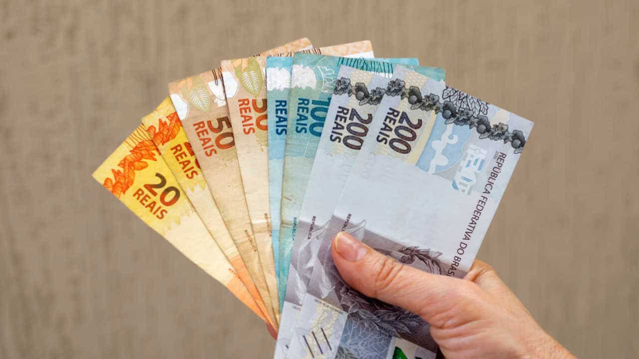 notas de R$ 20, R$ 50, R$ 100 e R$ 200 na mão