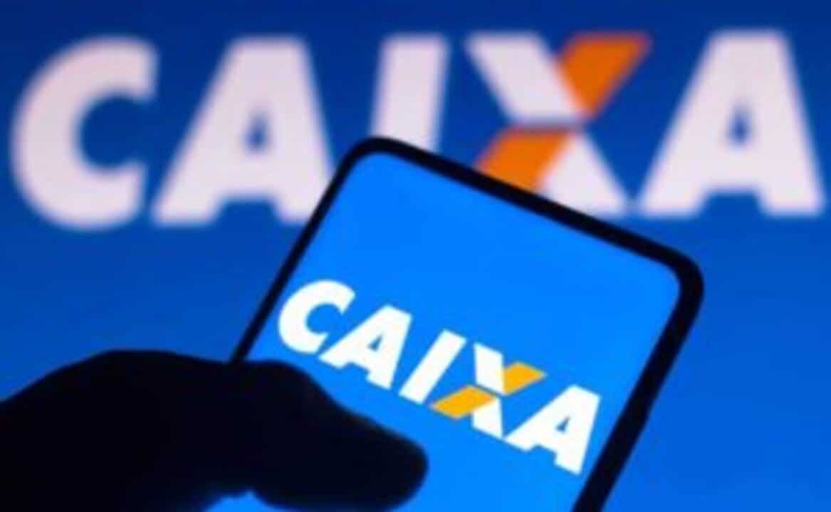Pessoa segurando um celular com a logo da Caixa na tela. Ao fundo, logo da Caixa em tamanho maior