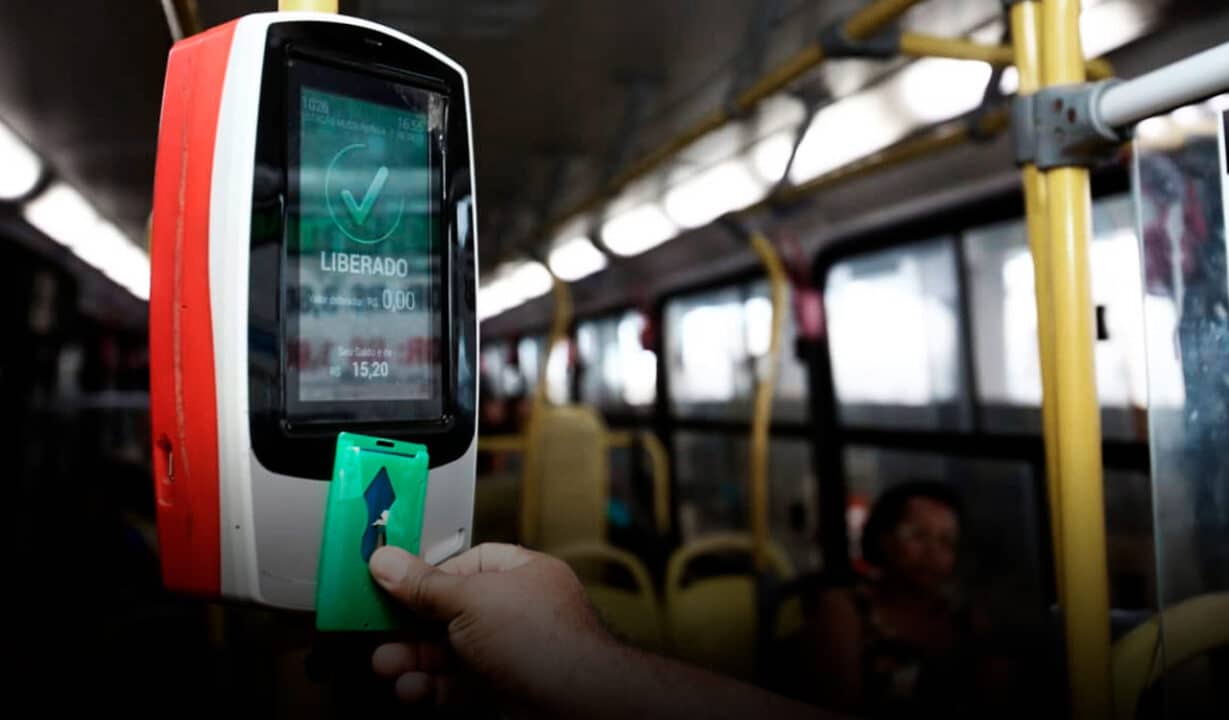 mão passando cartão de embarque em ônibus