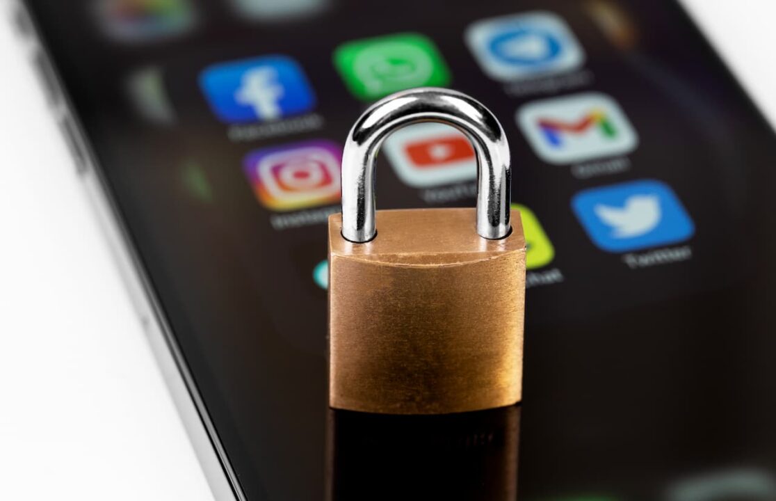 celular com aplicativos de redes sociais e um cadeado em cima do aparelho