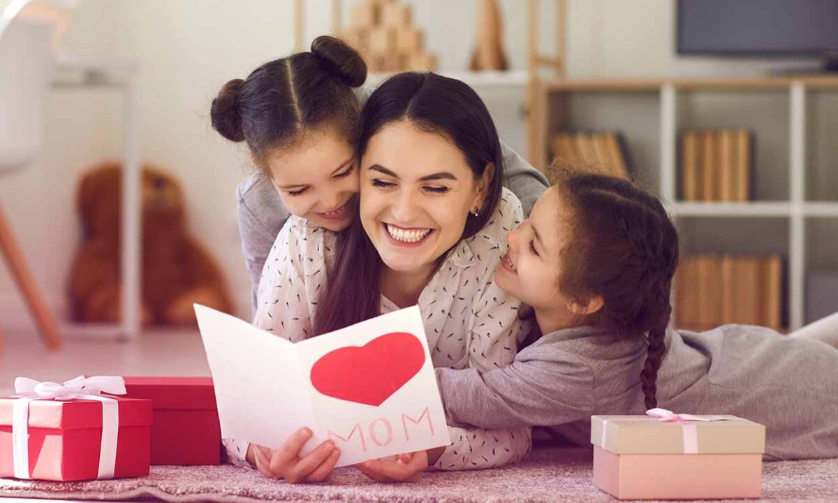 Mãe com duas filhas lendo cartão