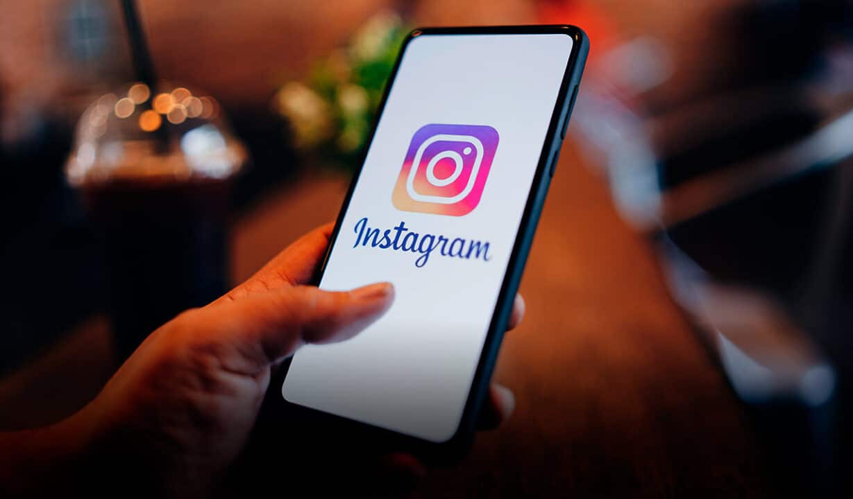Mão segurando celular com Instagram